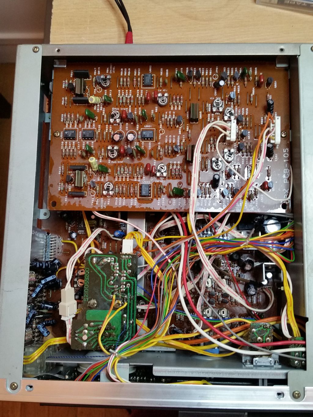L'intérieur vu du dessous, avec en premier plan la carte DBX (marron) et la petite carte (verte) qui supporte le moteur du potentiomètre d'enregistrement